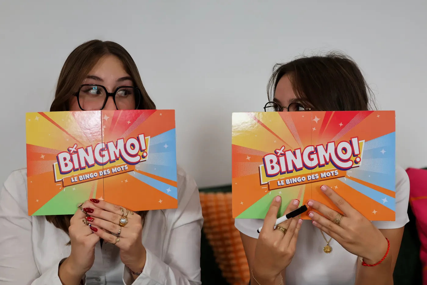 Deux amies cachent leur visage derrière une grille de Bingmo